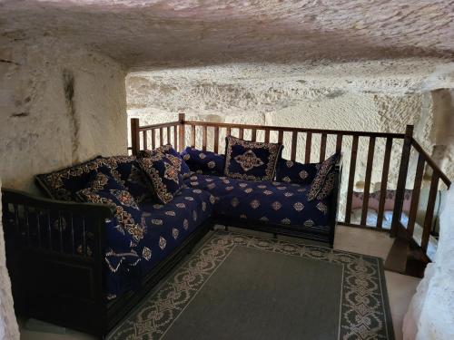 a living room with a blue couch in a wall at La grotte in Bourré