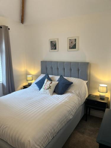 una camera da letto con un grande letto con cuscini blu di Bonny Cottage a Whitby