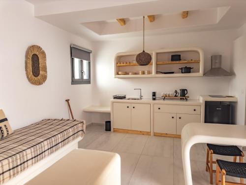 eine Küche und ein Wohnzimmer mit einem Bett und einem Tisch in der Unterkunft Alonia Suites in Naoussa