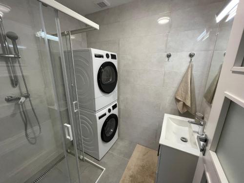 a bathroom with a washing machine in a shower at Apartmán NAVIA obklopený prírodou a spa in Rajecké Teplice