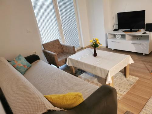 uma sala de estar com um sofá e uma mesa em Sunrise Apartment Struga em Struga