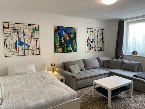 a living room with a bed couch and stained glass windows at Fiala Home in Neumünster