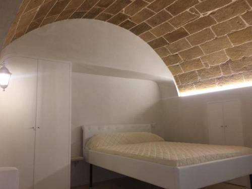 a bedroom with a bed under a brick wall at Sulle Mura Casavacanza in Gallipoli
