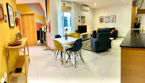 a kitchen and living room with a table and chairs at Aveiro Escapades Central City in Aveiro