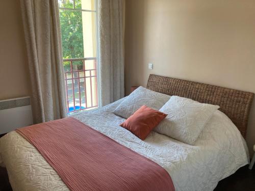 - un lit avec 2 oreillers et une fenêtre dans l'établissement T2 dans quartier résidentiel sur le Bassin Arcachon avec location de vélos, à Gujan-Mestras