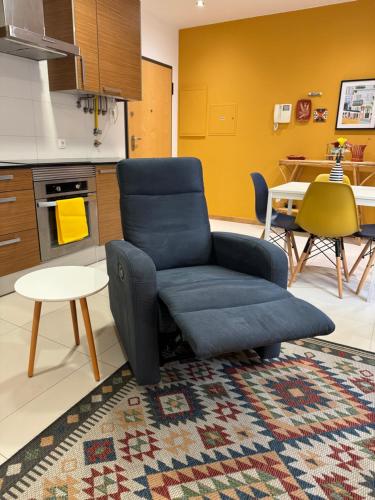 a living room with a blue chair and a table at Aveiro Escapades Central City in Aveiro
