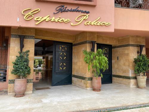 - l'entrée à un restaurant avec deux plantes en pot devant dans l'établissement Résidence Caprice Palace Hivernage, à Marrakech