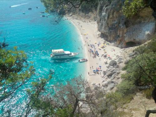 a boat on a beach with a group of people at Domo Annalisa in Tortolì