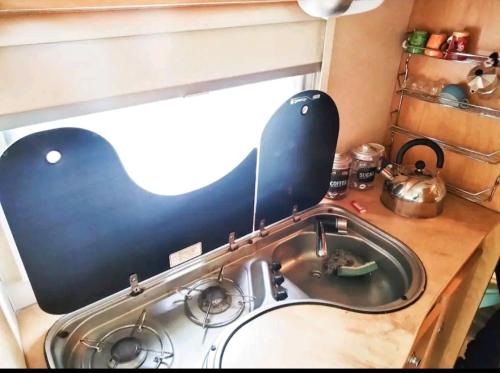 uma cozinha com um lavatório com uma tampa preta em Sweet Camper em Florença