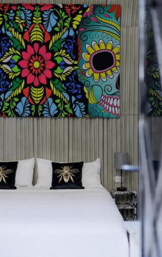 a bedroom with a bed with a painting on the wall at CENTRO DE LA CIUDAD CASA PAXI ESTUDIO8 in Mérida