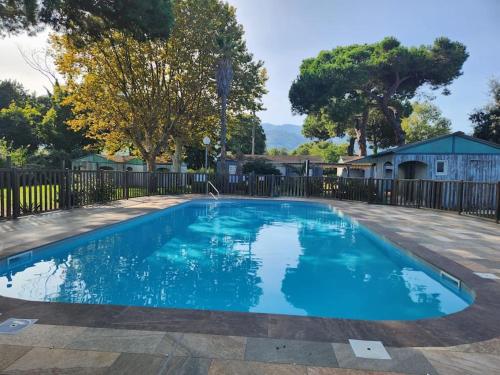 a swimming pool in a yard with a fence at Mini Villa Bord de Mer - Idylle BY MONARCA in San-Nicolao