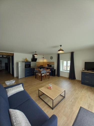 sala de estar con sofá azul y mesa en Gite Chez Guynette en Saint-Félix-de-Lunel