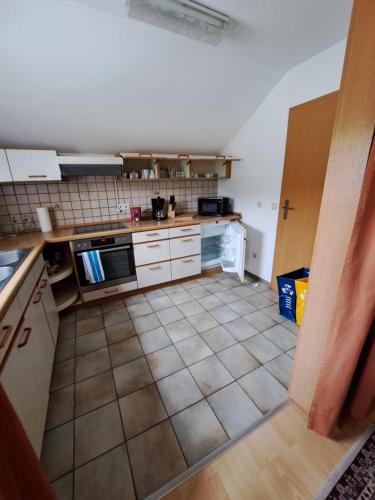 a kitchen with white cabinets and a tile floor at Wohnung Widdern in Widdern