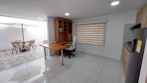 a kitchen with a desk and a table and chairs at Apartamento con aire acondicionado 3 camas 2 hab apt 101 in Floridablanca