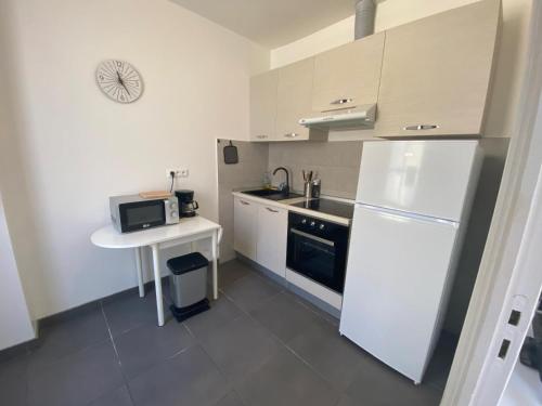 Elle comprend une petite cuisine équipée d'un réfrigérateur blanc et d'une table. dans l'établissement CENTRE VILLE, à Menton