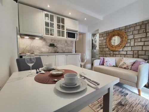 a kitchen and living room with a table and chairs at Apartments Vodaric in Cres