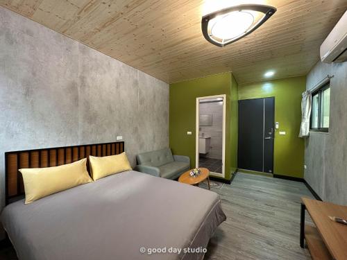 a bedroom with a bed and a couch and a chair at 真愛民宿-寵物友善-近東大門夜市-含車位 in Hualien City