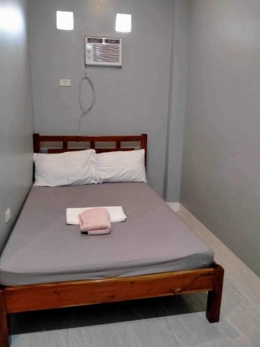 a bed in a room with a pink towel on it at Beachfront Guesthouse Siquijor in San Juan