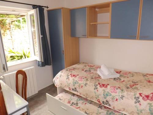 a small room with a bed and a window at Apartman Karmela in Zaton
