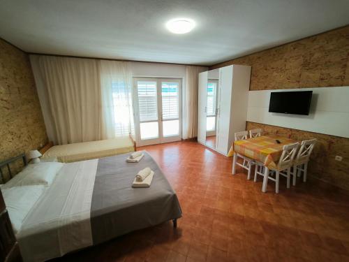 1 dormitorio con 1 cama, mesa y sillas en Apartments Marina, en Makarska