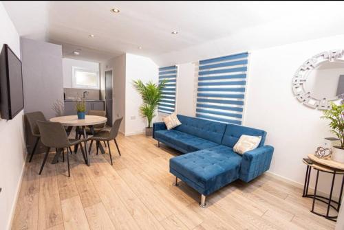 a living room with a blue couch and a table at Quaint 3BR l Market St Watford l Sleeps 8 in Watford