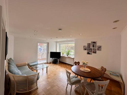 a living room with a table and chairs and a television at Ammersee Bungalow Verstecktes Juwel in Seenähe in Utting am Ammersee