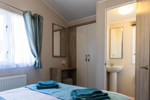 Porchfield的住宿－10 Beachlands，一间卧室配有床、水槽和镜子