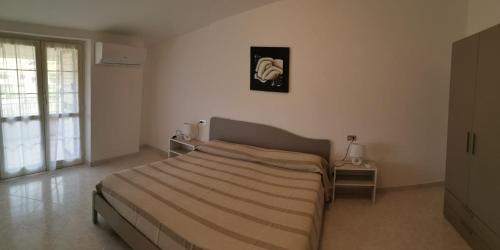 1 dormitorio con 1 cama y una foto en la pared en Le Palme di Riace, en Riace Marina