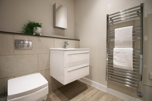 y baño con aseo blanco y lavamanos. en Casablanca 5 - Cardiff Bay - 1 Bed Apartment en Cardiff