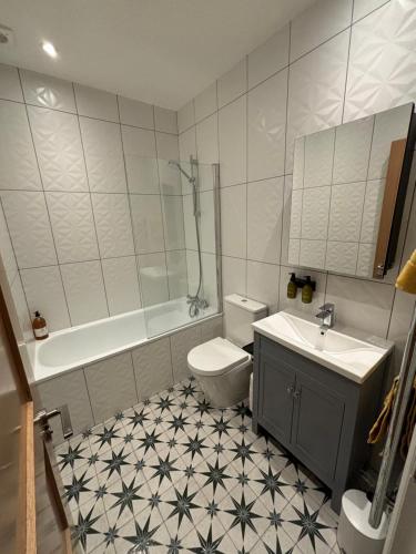 y baño con aseo, bañera y lavamanos. en Sandgate Seaview Apartment en Sandgate