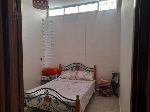 1 dormitorio con cama y ventana en Apartment Surf, en Skhirat