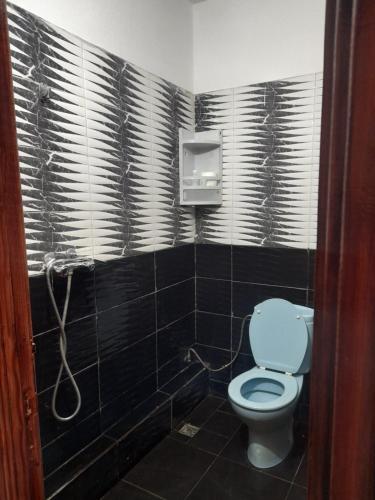 a bathroom with a toilet in a black tiled room at Apartment Surf in Skhirat