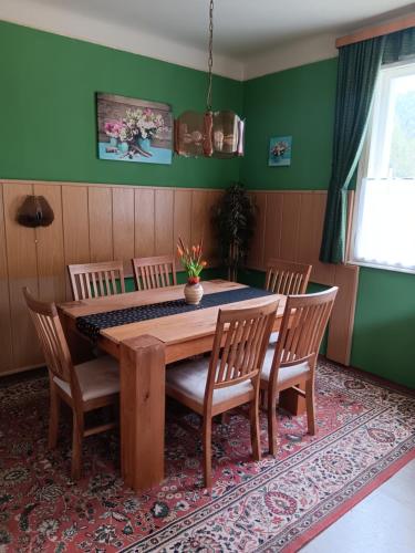 jadalnia z drewnianym stołem i krzesłami w obiekcie Urlaub am Bauernhof w mieście Trattenbach