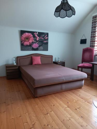 a bedroom with a large bed and a chair at Urlaub am Bauernhof in Trattenbach