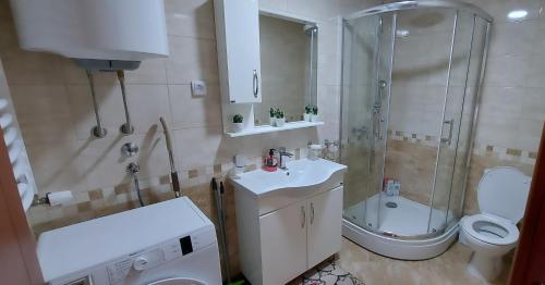een badkamer met een douche, een toilet en een wastafel bij Apartman Panorama in Požarevac