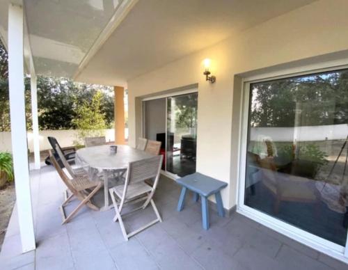 un patio avec une table et des chaises sur un porche dans l'établissement T3 Rdc Accès Plage à 50 m - Rupione, à Pietrosella