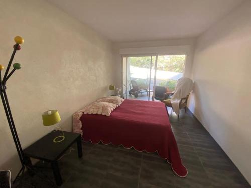 une chambre avec un lit avec une couverture rouge dans l'établissement T3 Rdc Accès Plage à 50 m - Rupione, à Pietrosella