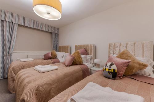 a bedroom with two beds and a couch at Stylish Spacious Retreat Luxury 2 Bedroom Haven 2 in London