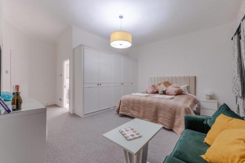 a white bedroom with a bed and a couch at Stylish Spacious Retreat Luxury 2 Bedroom Haven 2 in London