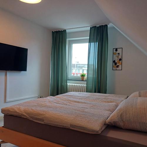 a bedroom with a bed with green curtains and a window at Ferienhaus mit 4 Schlafzimmer in Pansdorf