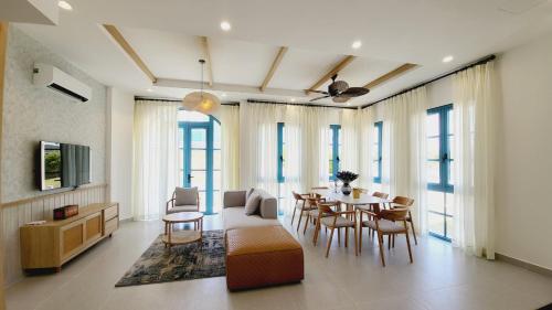 a living room with a couch and a table and chairs at Villa Minh Châu in Bình Tú