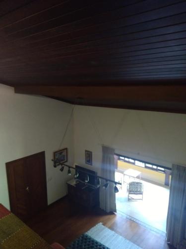 a bedroom with a window and a room with a patio at Bromélia Sabiá & Cia in Teresópolis