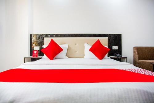 ein Schlafzimmer mit einem großen Bett mit roten Kissen in der Unterkunft Hotel Raj Ganga Haridwar Near Raja Ji National park Jeep Safari - Excellent Customer Choice- Best Seller in Haridwar