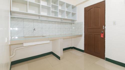 馬尼拉的住宿－RedDoorz @ Western Bicutan Transients Inn，厨房配有柜台、水槽和门