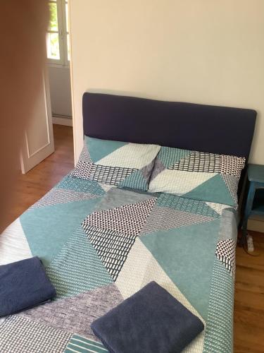 a bed with a quilt and pillows on it at Château De Grenier Gite in Saint-Léger