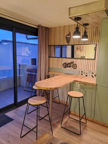een keuken met een houten tafel en 2 krukken bij TERRA BELLA 2 in Grosseto-Prugna