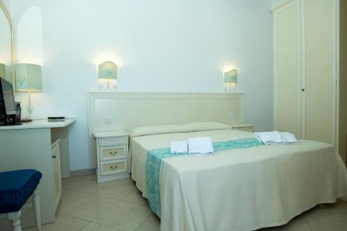 a bedroom with a bed with two towels on it at La Locanda - Guesthouse in Sardinia in Porto San Paolo