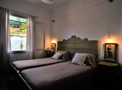 1 dormitorio con 2 camas y ventana en Η αυλή της Ασπασίας, Χανιά Κρήτη, en Lákkoi