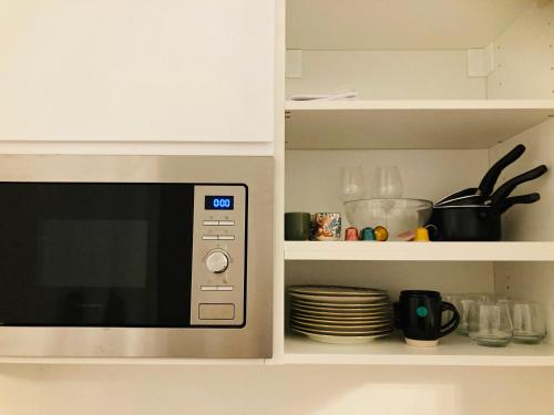 un four à micro-ondes dans une cuisine avec des assiettes et des plats dans l'établissement AU LION D OR, à Auxerre