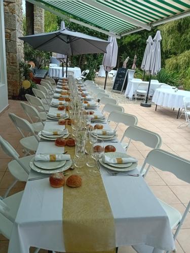 a long table with plates and wine glasses on it at Les Amis du Moulin 